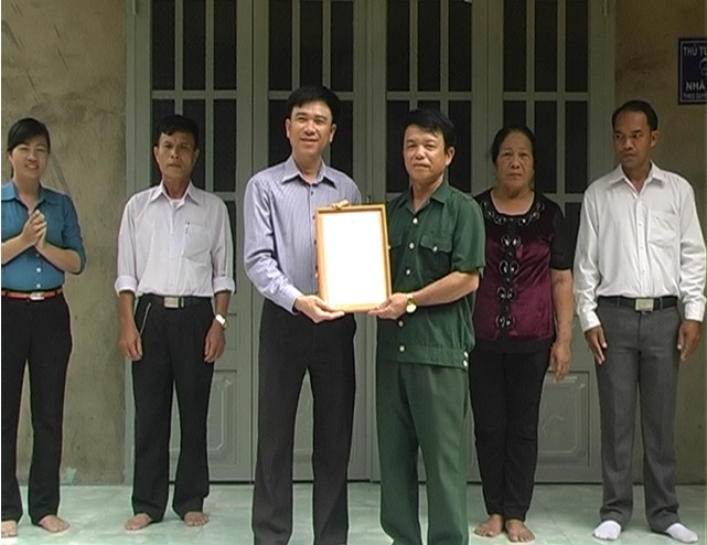 Ông Nguyễn Khắc Vĩnh trao quyết định của  UBND huyện cho gia đình ông Phùng Dĩ Thắn